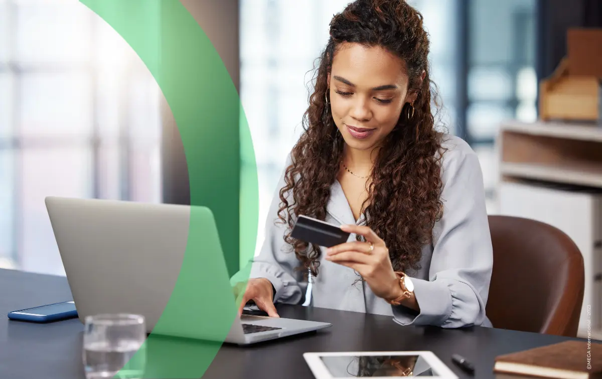 Woman in front of laptop reading credit card details